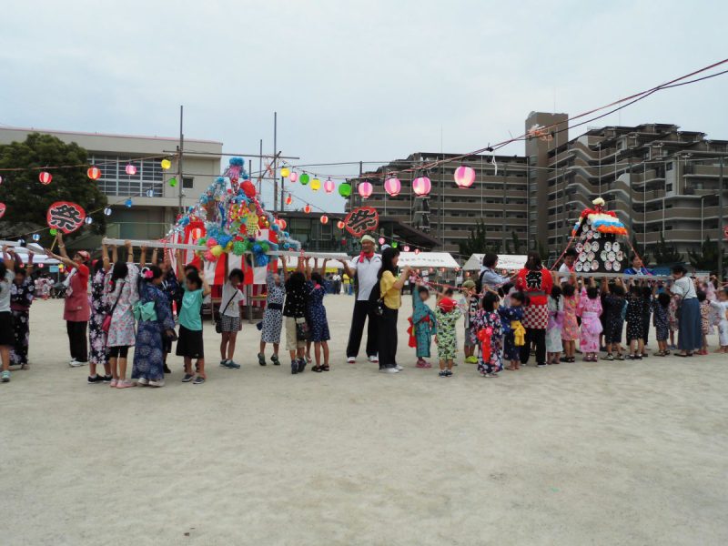 みこしを担ぎあげる子ども達